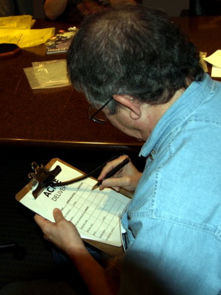 Guy taking pen to clipboard