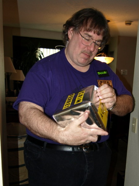 Crim Ferret holding and opening a foil-wrapped parcel.