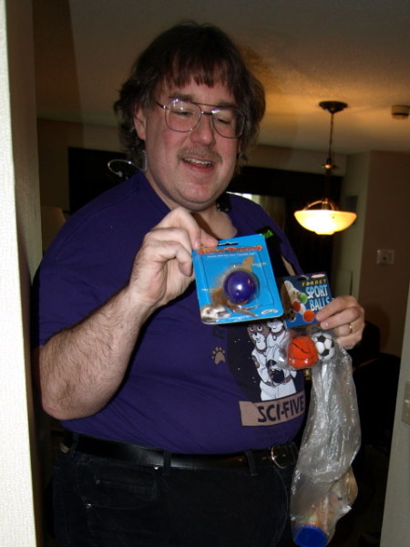 Crim holding a couple ferret toys.