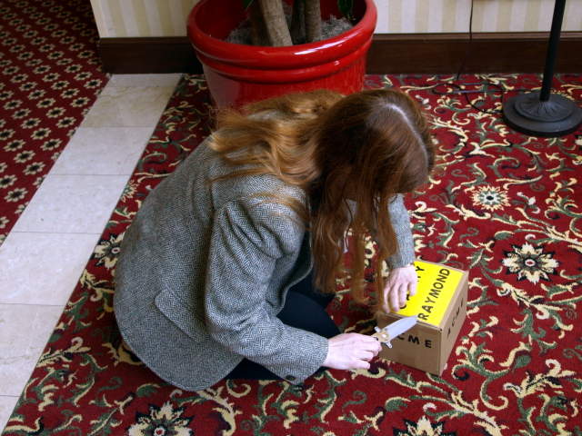 Cathy using a nig knife to open a box.