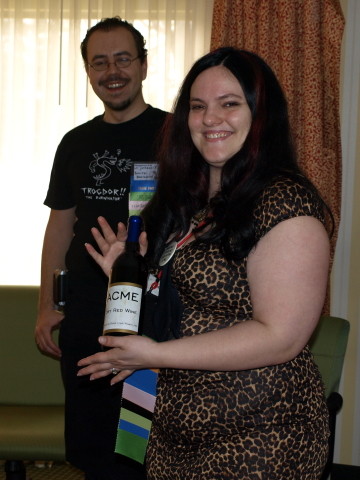 Catherynne holding a bottle of red wine.